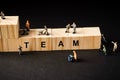 Miniature builders figure with wooden blocks with Ã¢â¬ÅTEAMÃ¢â¬Â wordings